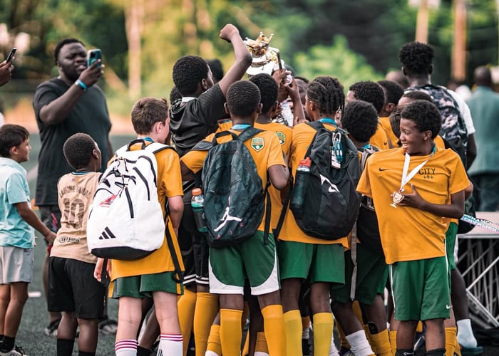 Diverse youth soccer players huddling and cheering together
