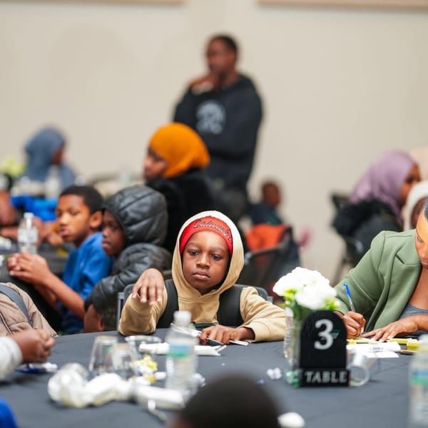 Students at a panel discussion table with microphones at a youth leadership event