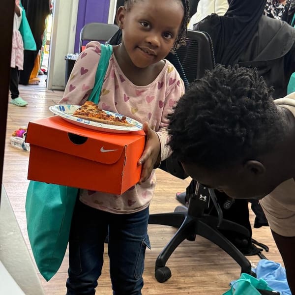 Child receiving a backpack full of school supplies