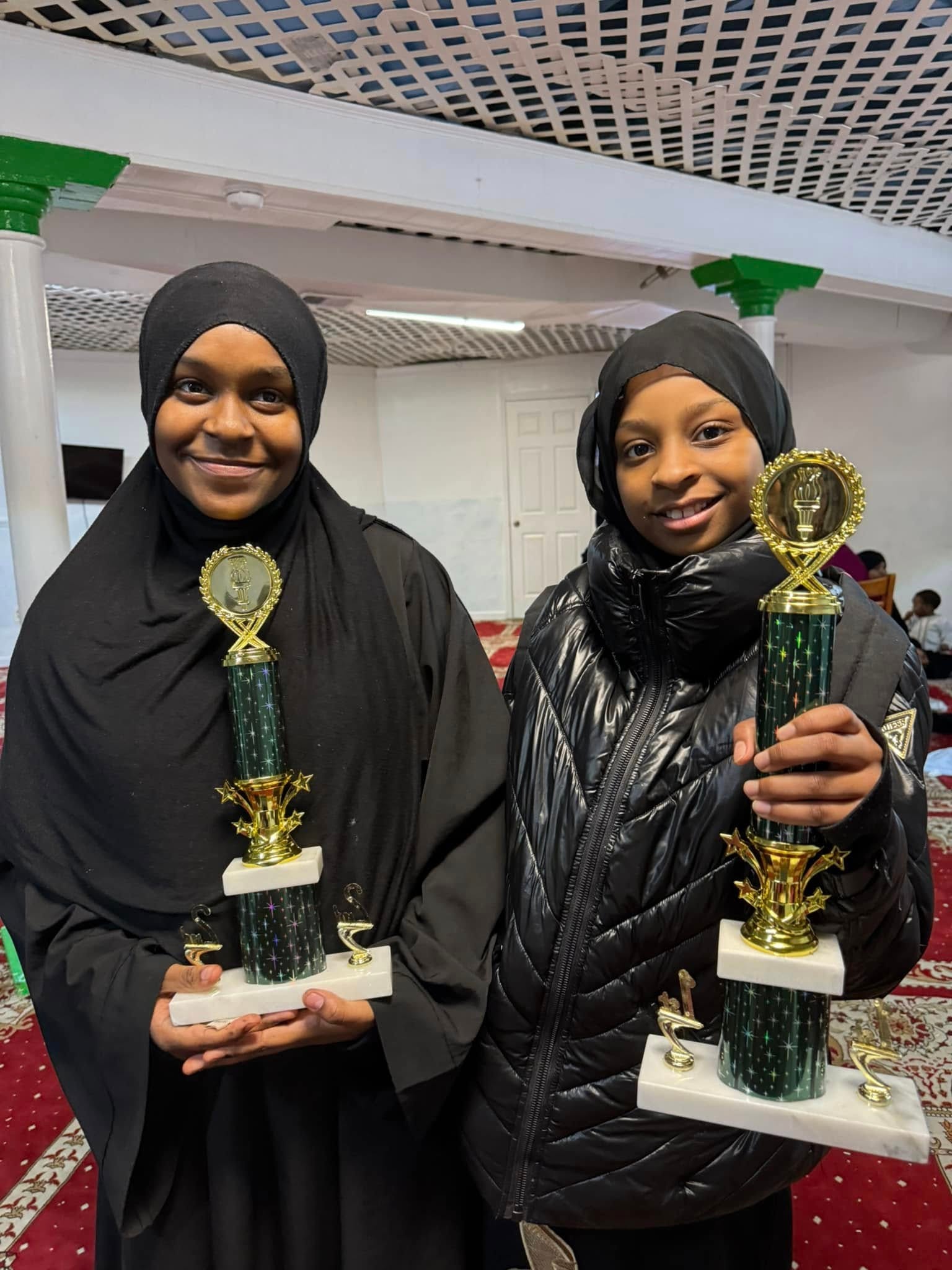 Girls holding trophy awards