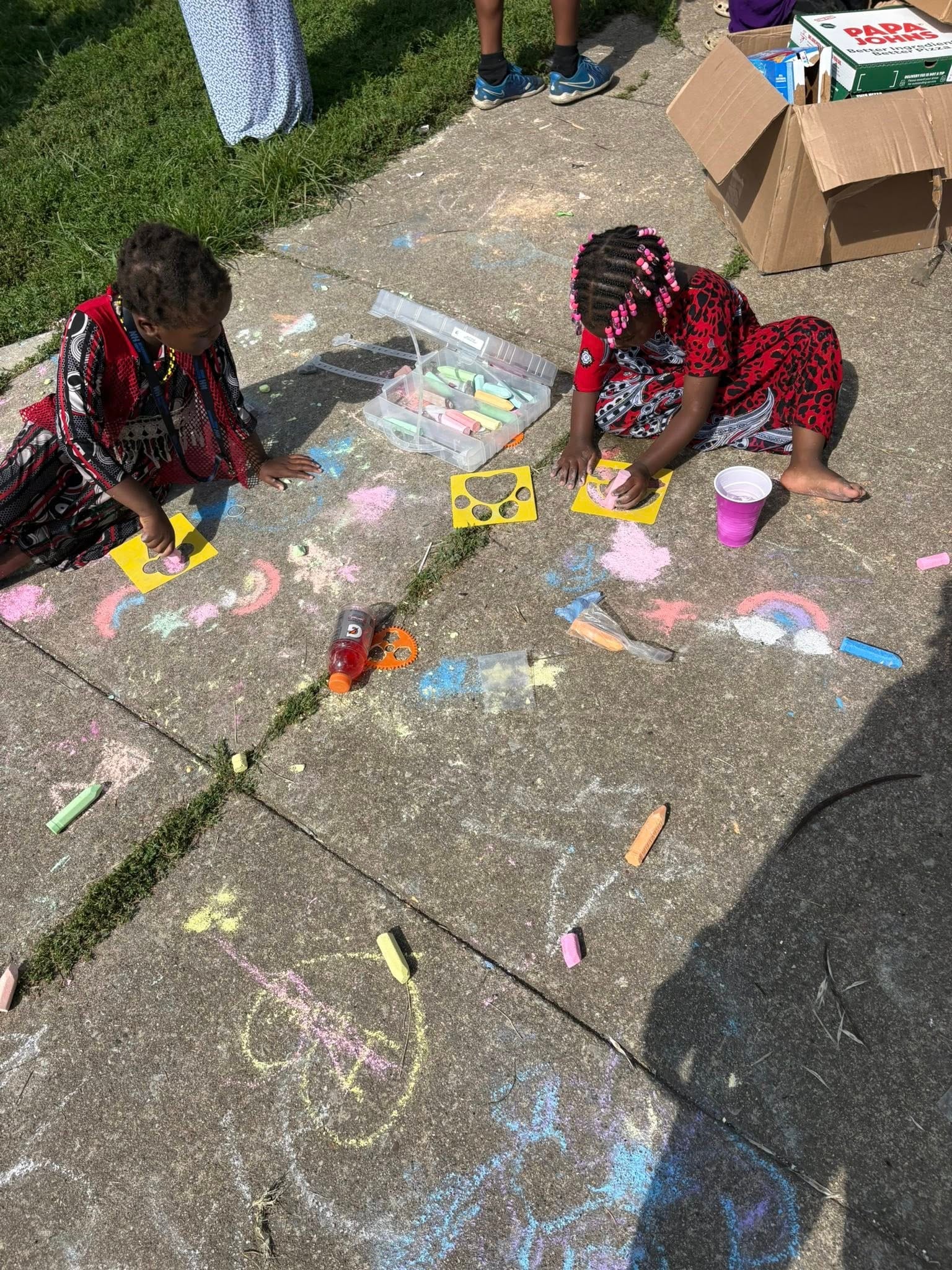 Children drawing with sidewalk chalk outdoors