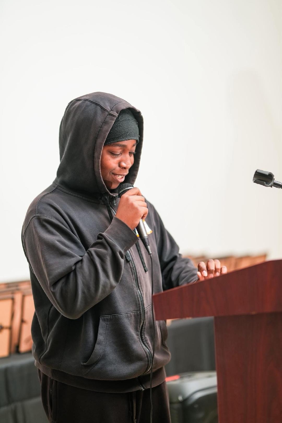 Young boy speaking at a podium with an adult