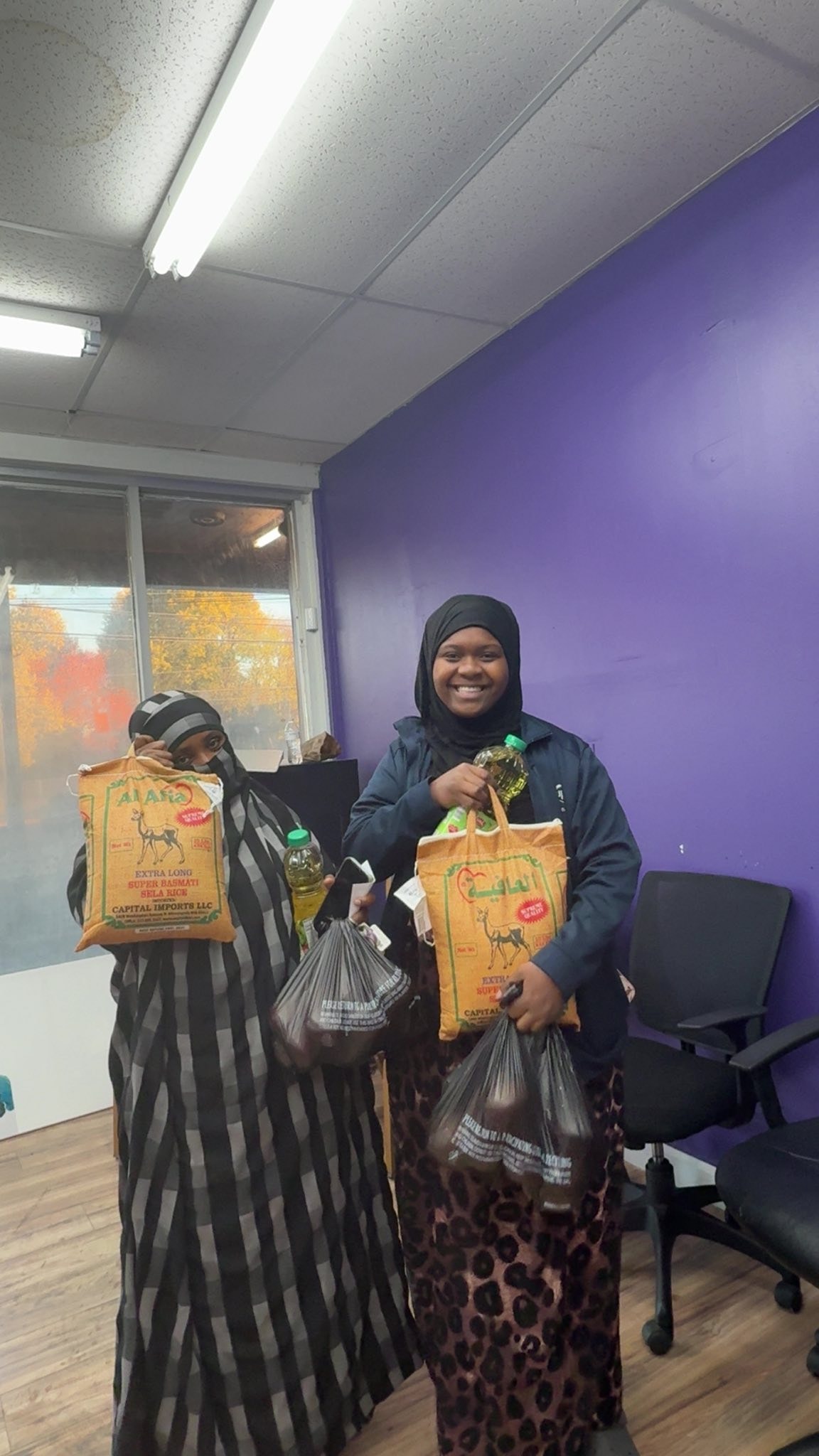 Two women holding grocery bags indoors