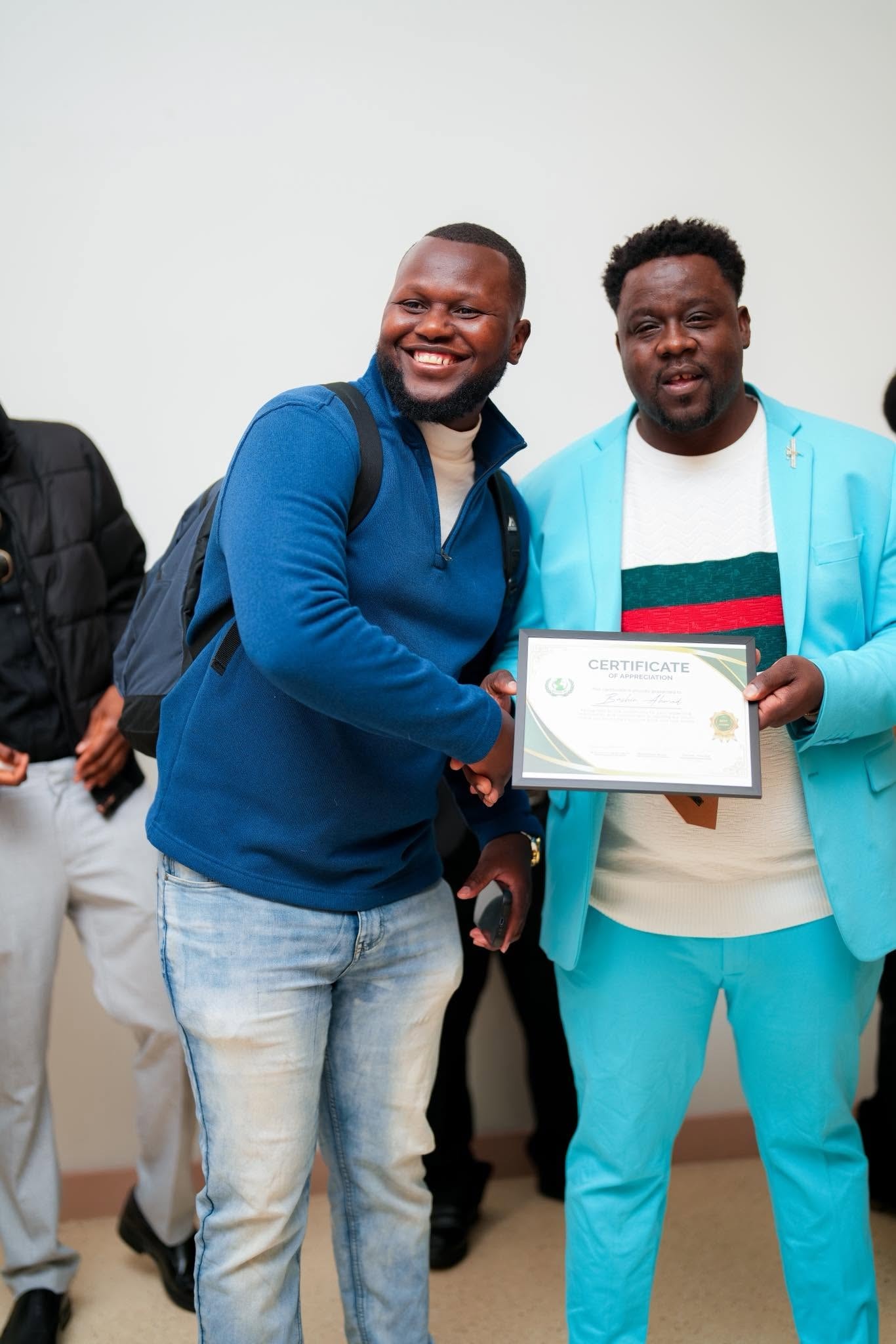 Two men holding a certificate and smiling