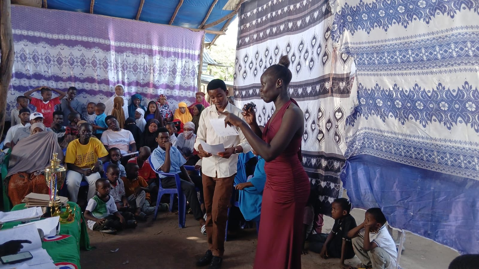 Community gathering under a tent with an audience