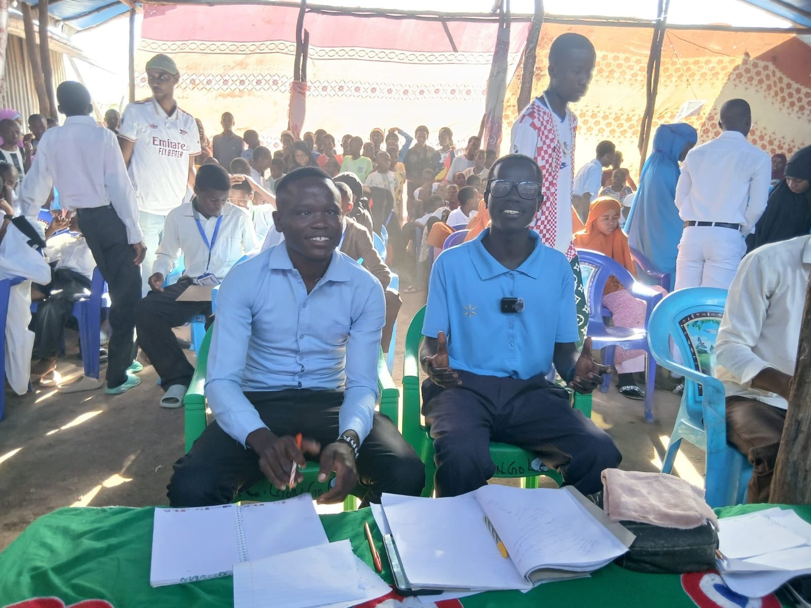 Community gathering under a tent with local officials