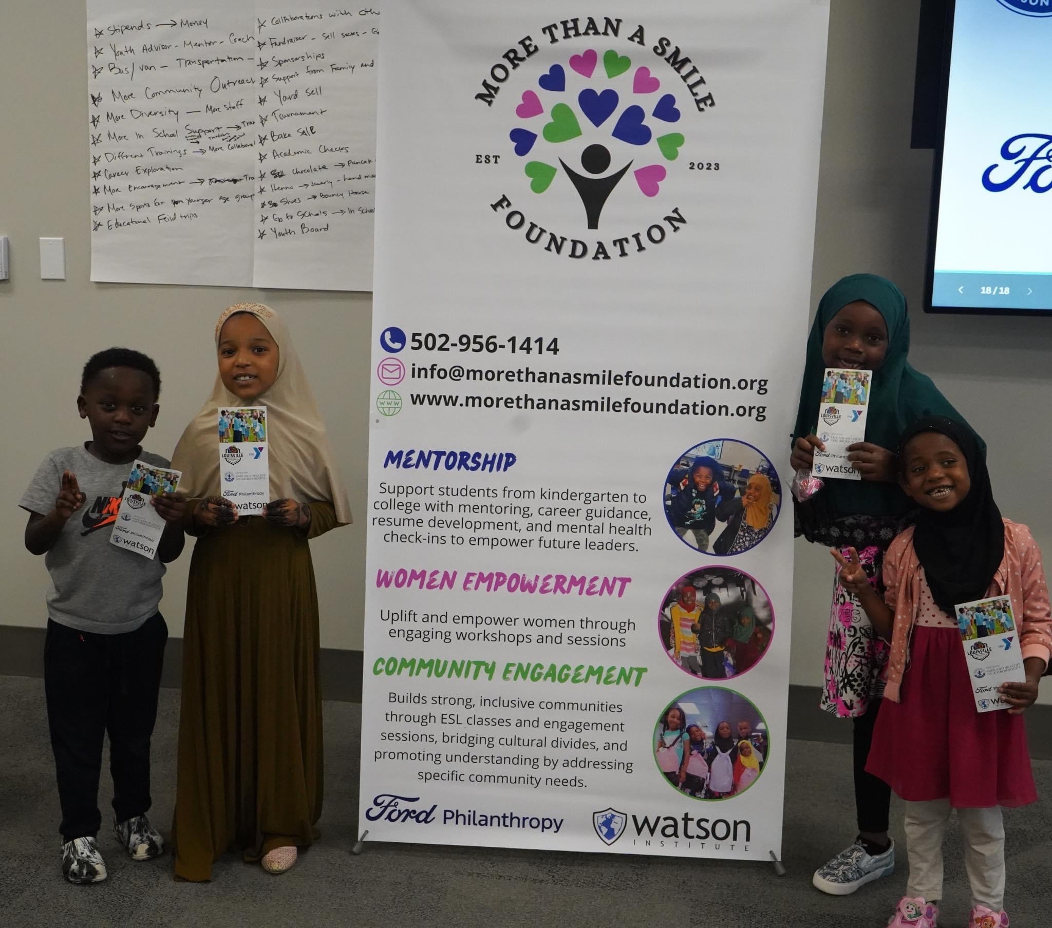 Children holding More Than A Smile Foundation cards